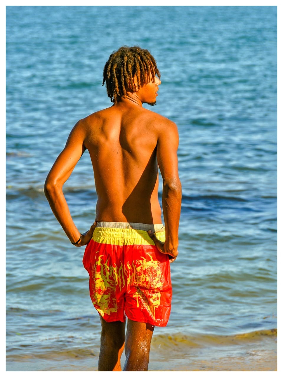 Guest standing in the shallows looking out along the shoreline