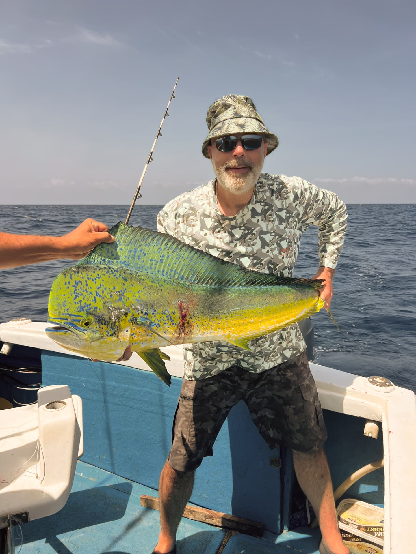 Guest holding a freshly caught dorado on a fishing boat