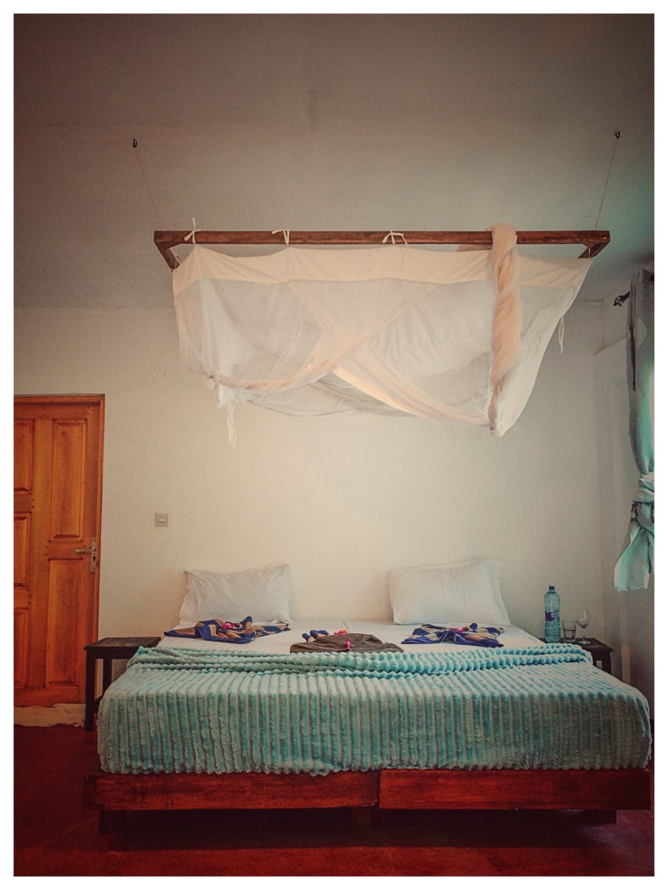 Double bed under a mosquito net in Upepo