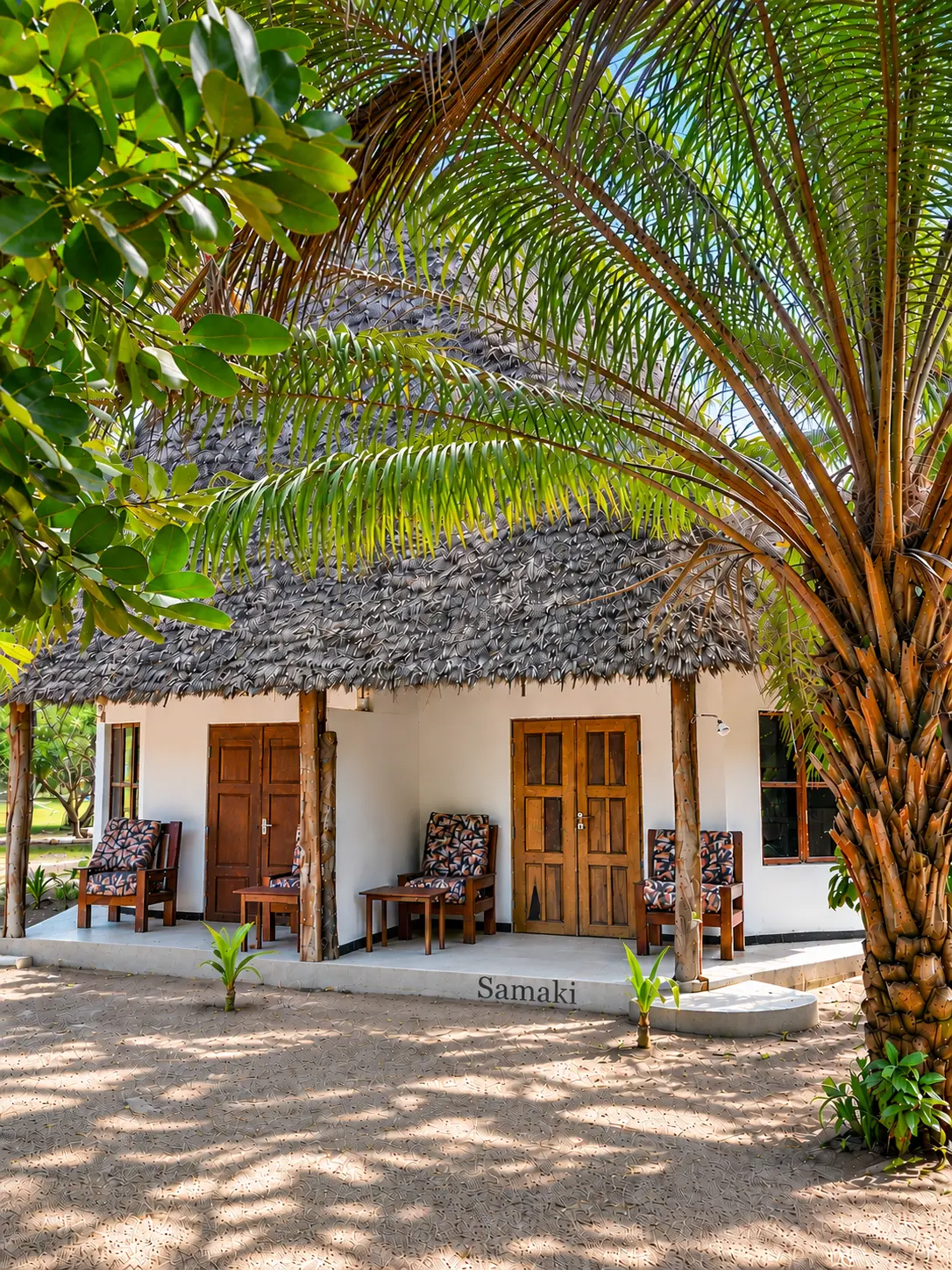 Samaki bungalow with makuti roof and veranda among palms