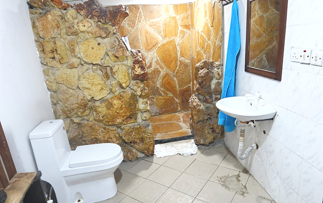 Bathroom with coral stone rain shower in Samaki