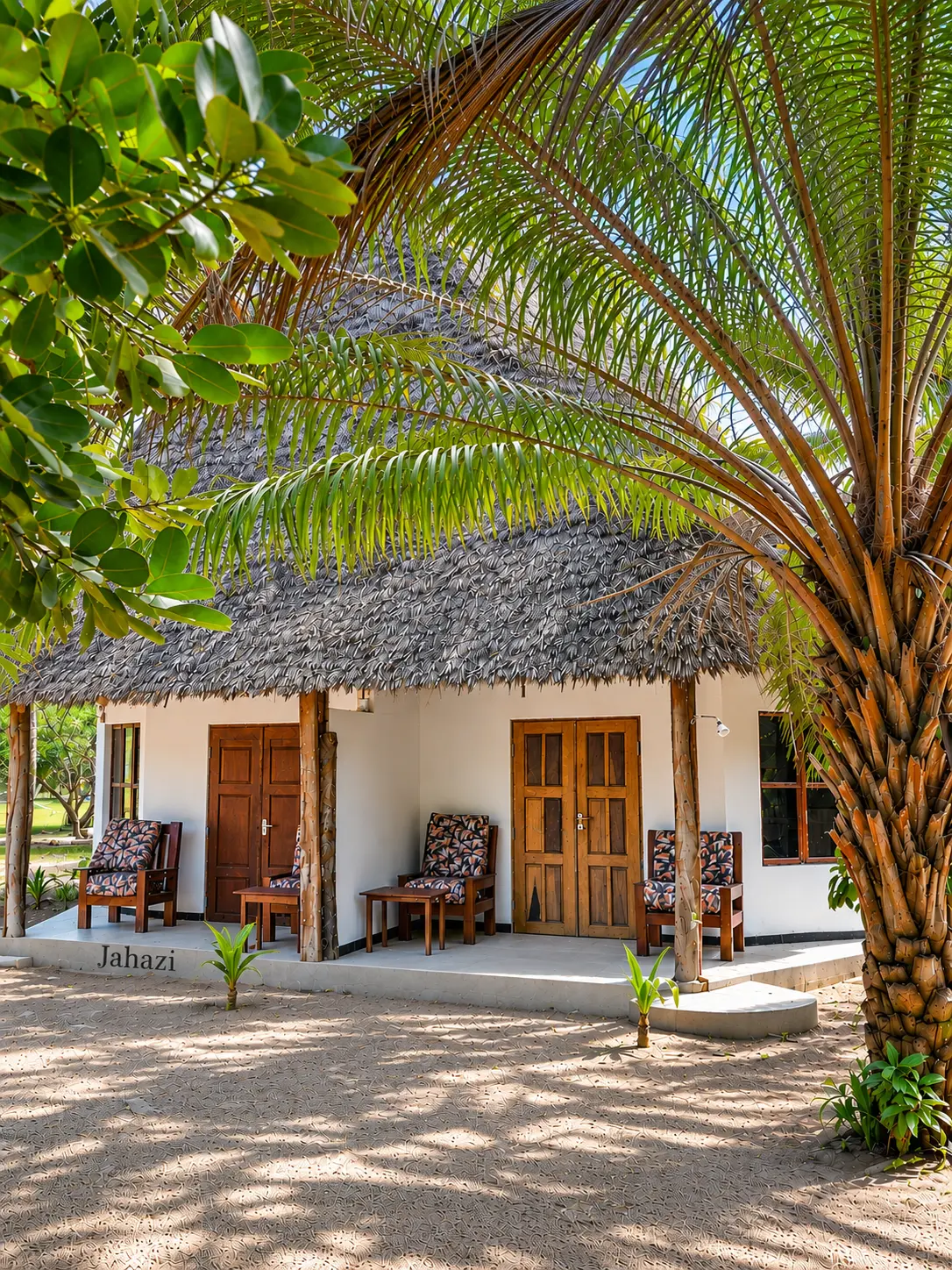 Jahazi bungalow with makuti roof seen through palm fronds