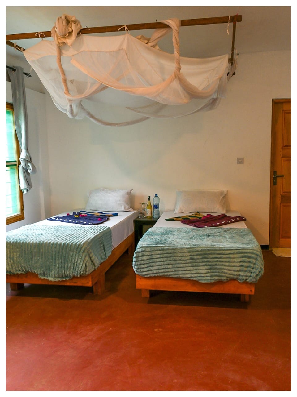 Two single beds under a mosquito net in Nanga