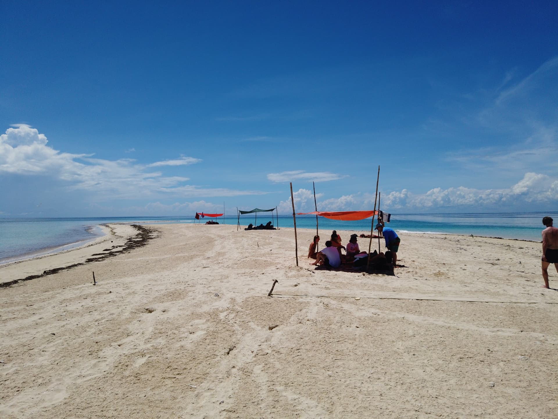 Snorkelers resting under shade sails on the Maziwe sandbank island