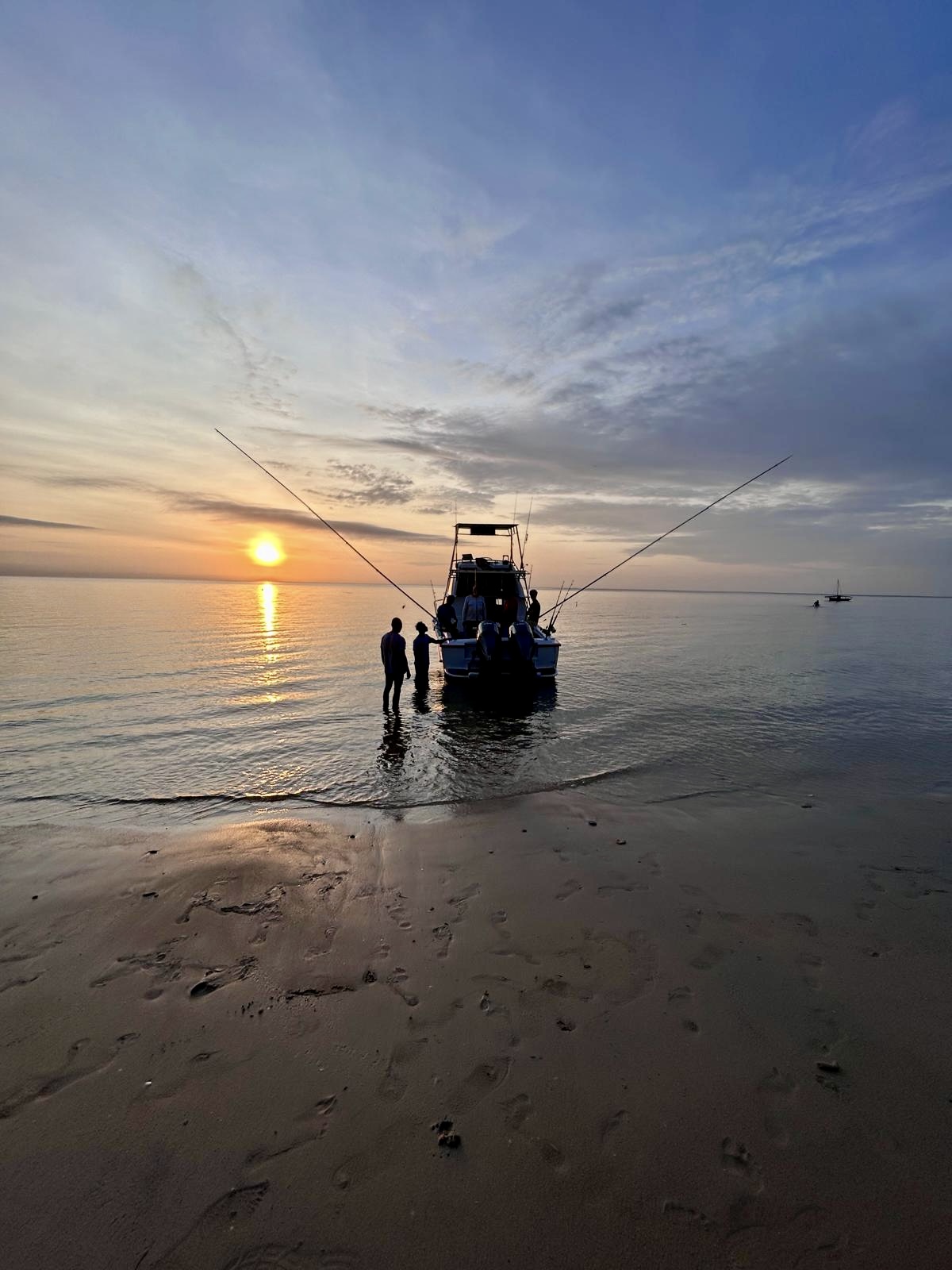 Fishing boat at the shoreline at sunrise with rods rigged